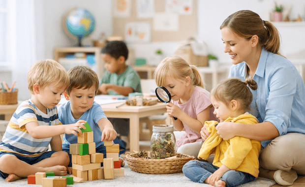 Förskolebarn och pedagog som leker och utforskar tillsammans i en ljus och färgglad förskolemiljö.